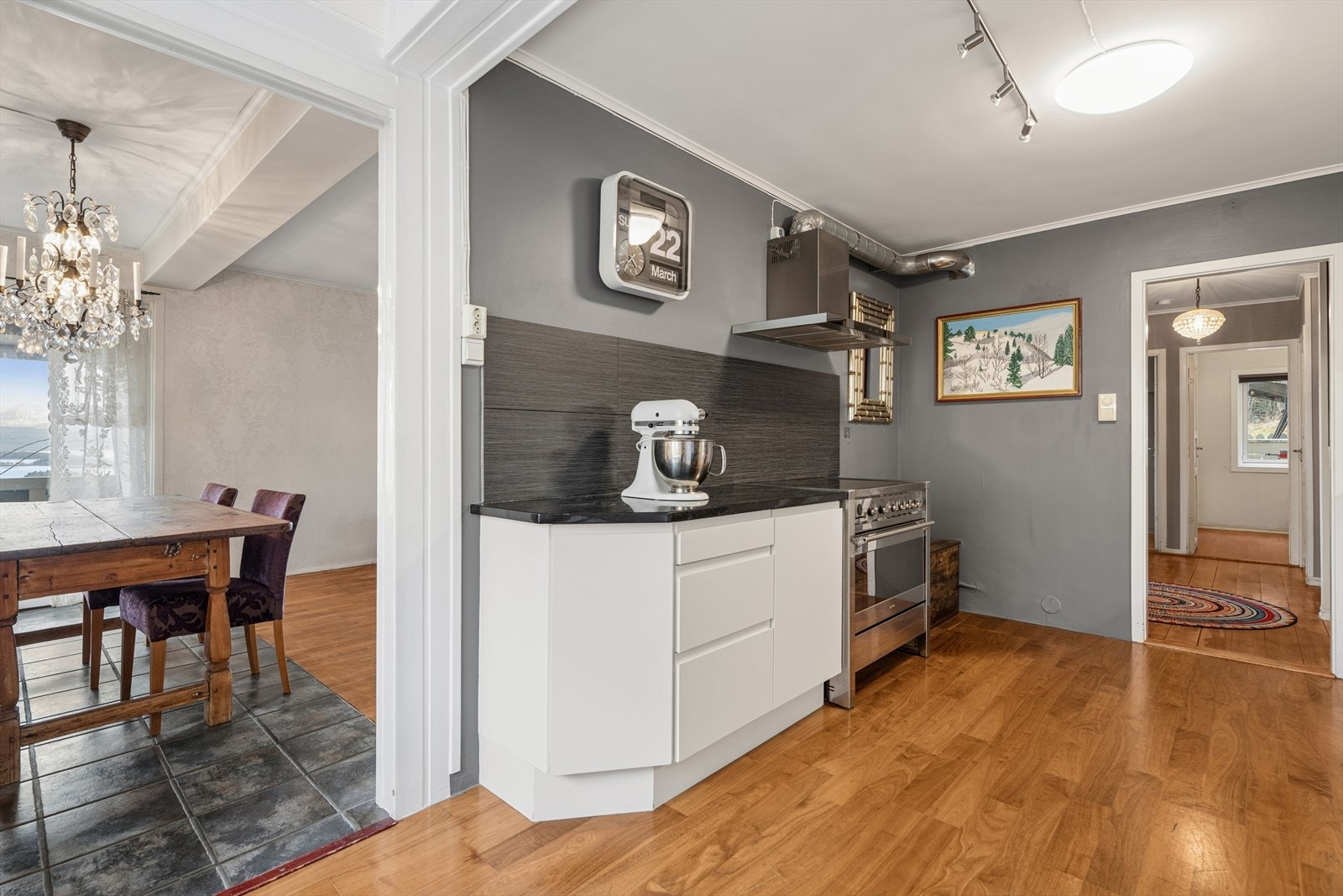 Et tidløst kjøkken med innredningen av glatte fronter og benkeplate i heltre og stein. Galleribilde