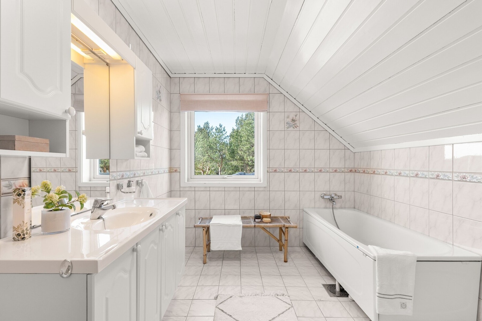 Romslig og flislagt bad med en praktisk planløsning og god plass til daglig bruk. Badet har vegghengt servantinnredning med heldekkende servant, samt speil med overlys og stikkontakt - en funksjonell løsning for både morgen- og kveldsrutiner. Galleribilde