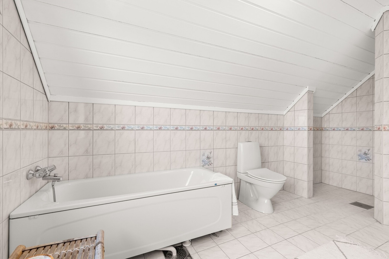 Badet er innredet med både dusjnisje og badekar, noe som gir fleksibilitet og komfort i hverdagen. I tillegg er det gulvmontert toalett. Galleribilde