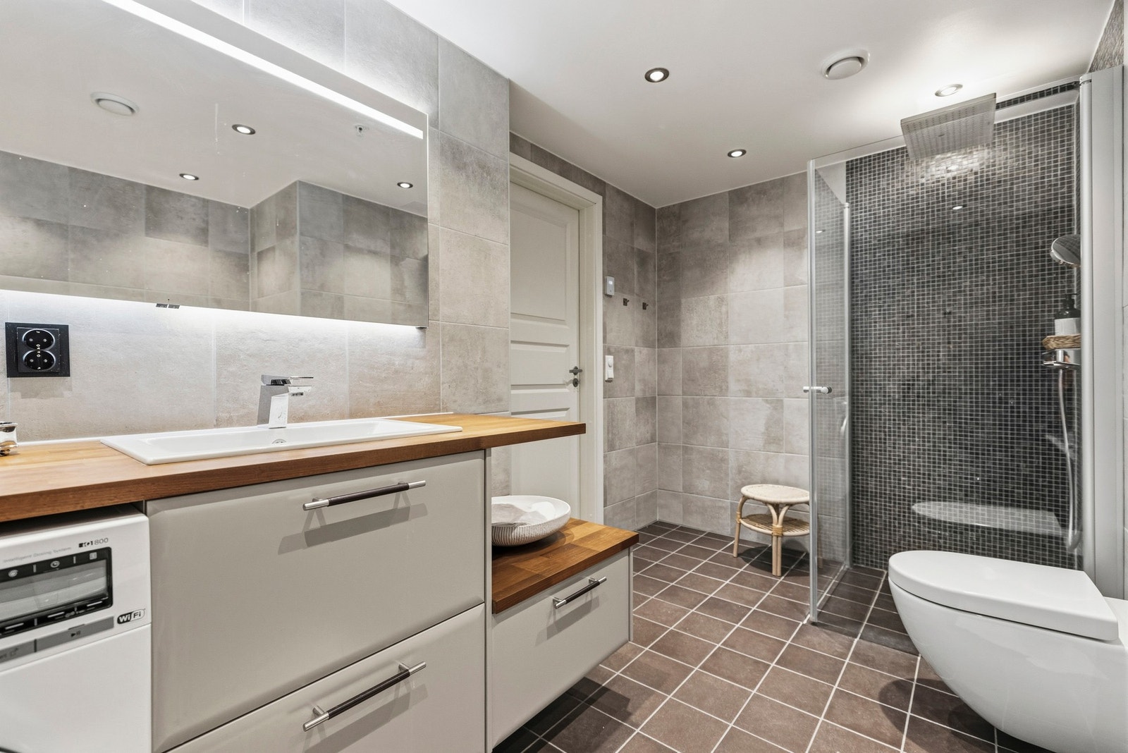 Dusjhjørne med glassvegg, regndusj og hånddusj, samt badekar for lange, rolige kvelder Galleribilde