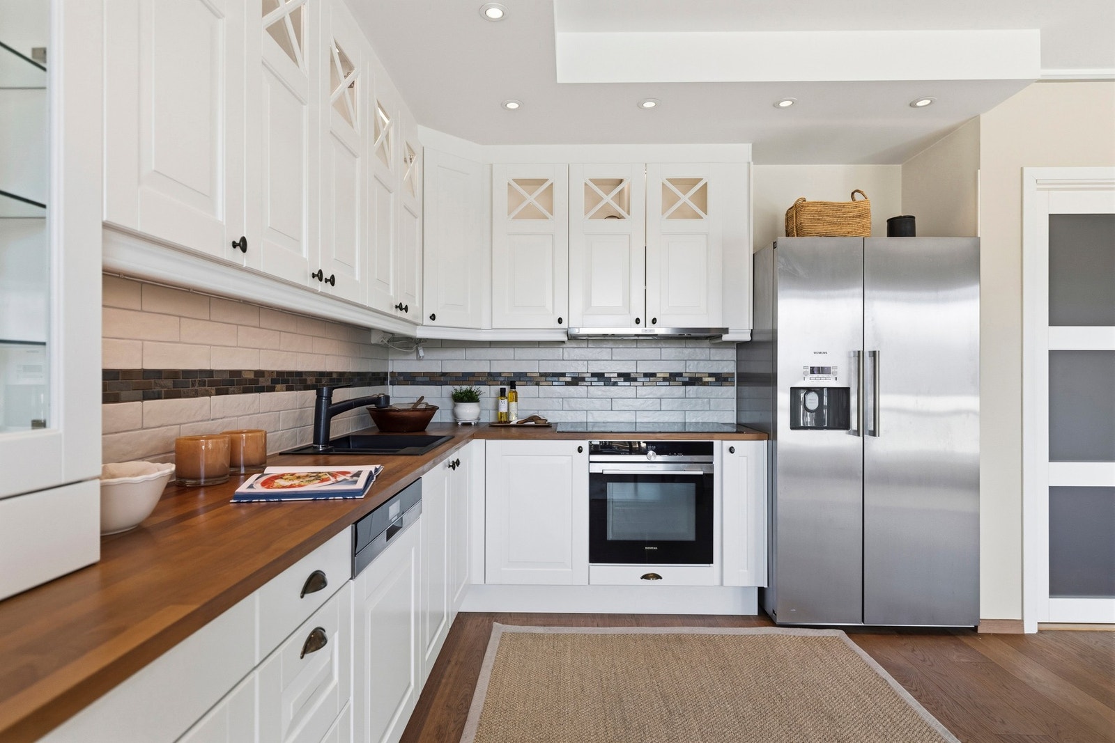 Flislagt vegg over benkeplaten gjør renholdet enkelt, og sammen med downlights i himlingen får du et jevnt og behagelig lys i hele rommet. Galleribilde