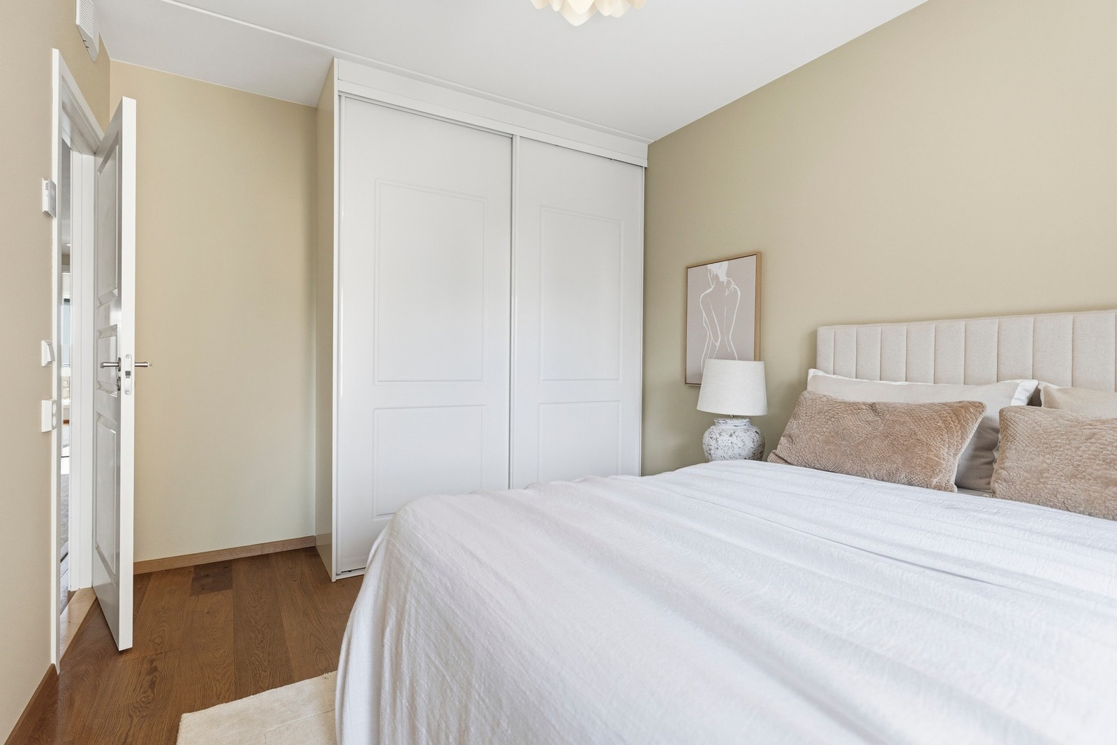 Integrert garderobeløsning med glatte fronter og detaljer i tre tilfører rommet både funksjonalitet og et varmt, eksklusivt uttrykk. Galleribilde