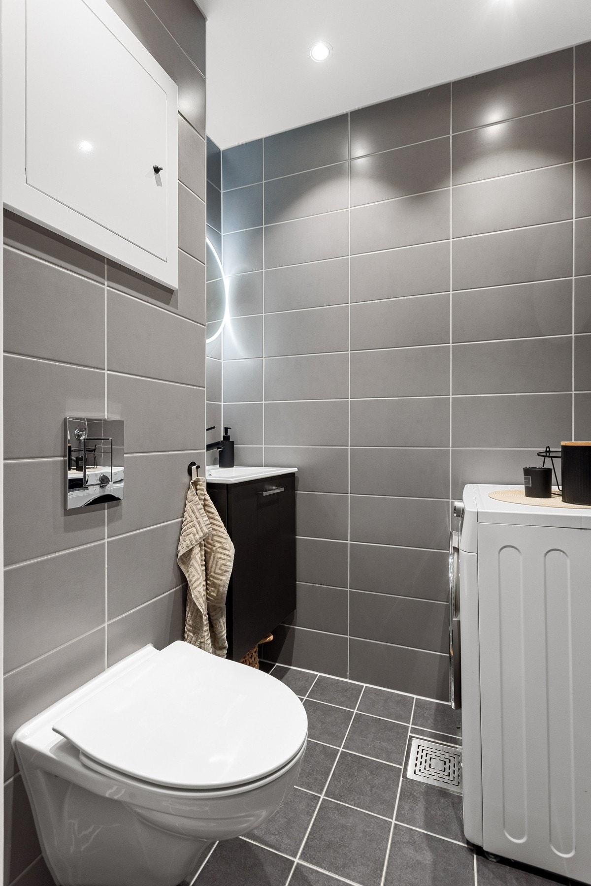 I tilknytning til soverom 2 er det et ekstra toalettrom kombinert med vaskerom. Også dette våtrommet ble moderne oppusset i regi av sameiet i 2022 med fliser på gulv og vegger, deilig gulvvarme og downlights i himlingen. Galleribilde