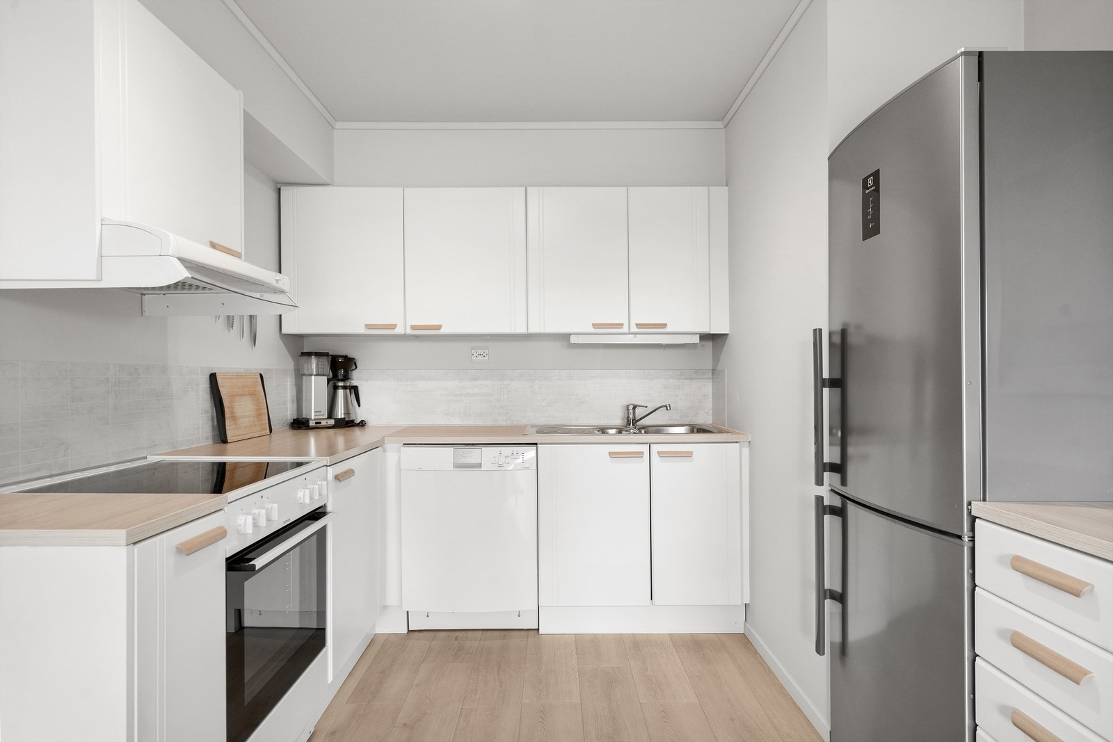 Praktisk kjøkken med laminatbenkeplate og glatte, hvite fronter. Rommet er sikret med Waterguard lekkasjestopper. Galleribilde