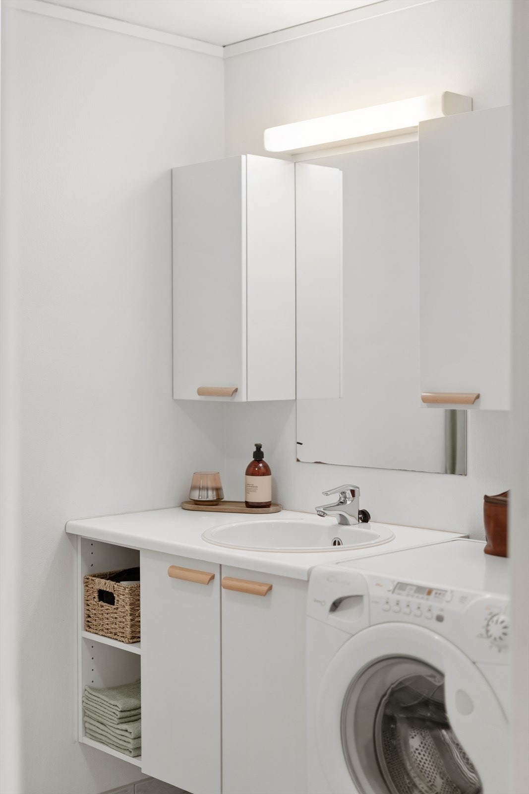 Baderomsinnredning med servant og god skapplass. Rommet har mekanisk avtrekk. Galleribilde