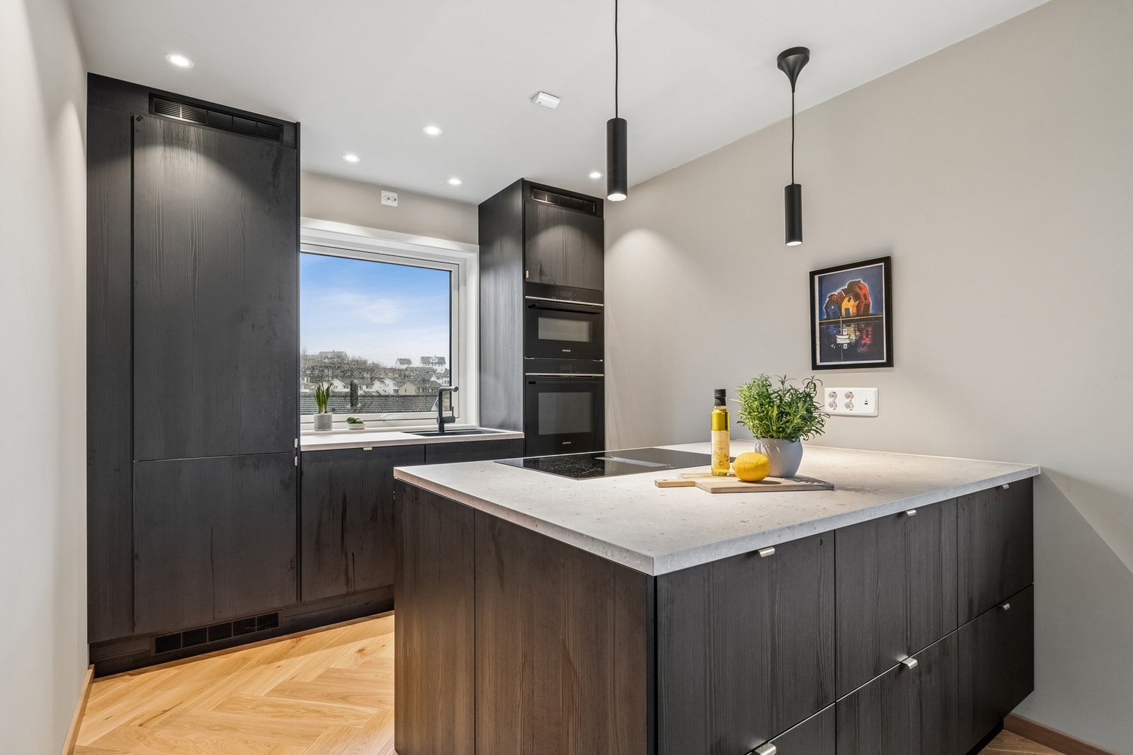 Delikat kjøkkeninnredning med halvøy med oppbevaringsmuligheter på begge sider. Galleribilde