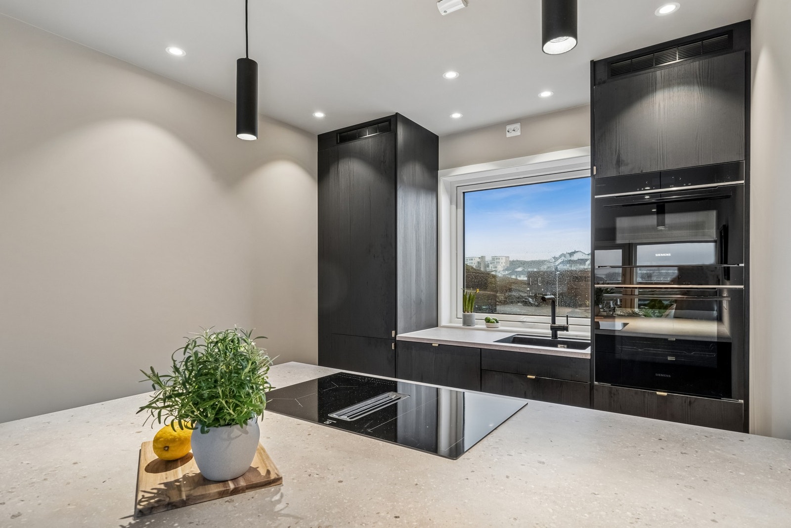 Integrerte hvitevarer som kjøl/frys kombi, oppvaskmaskin, stekeovn, induksjonstopp med avtrekk, mikro og vinskap. Galleribilde