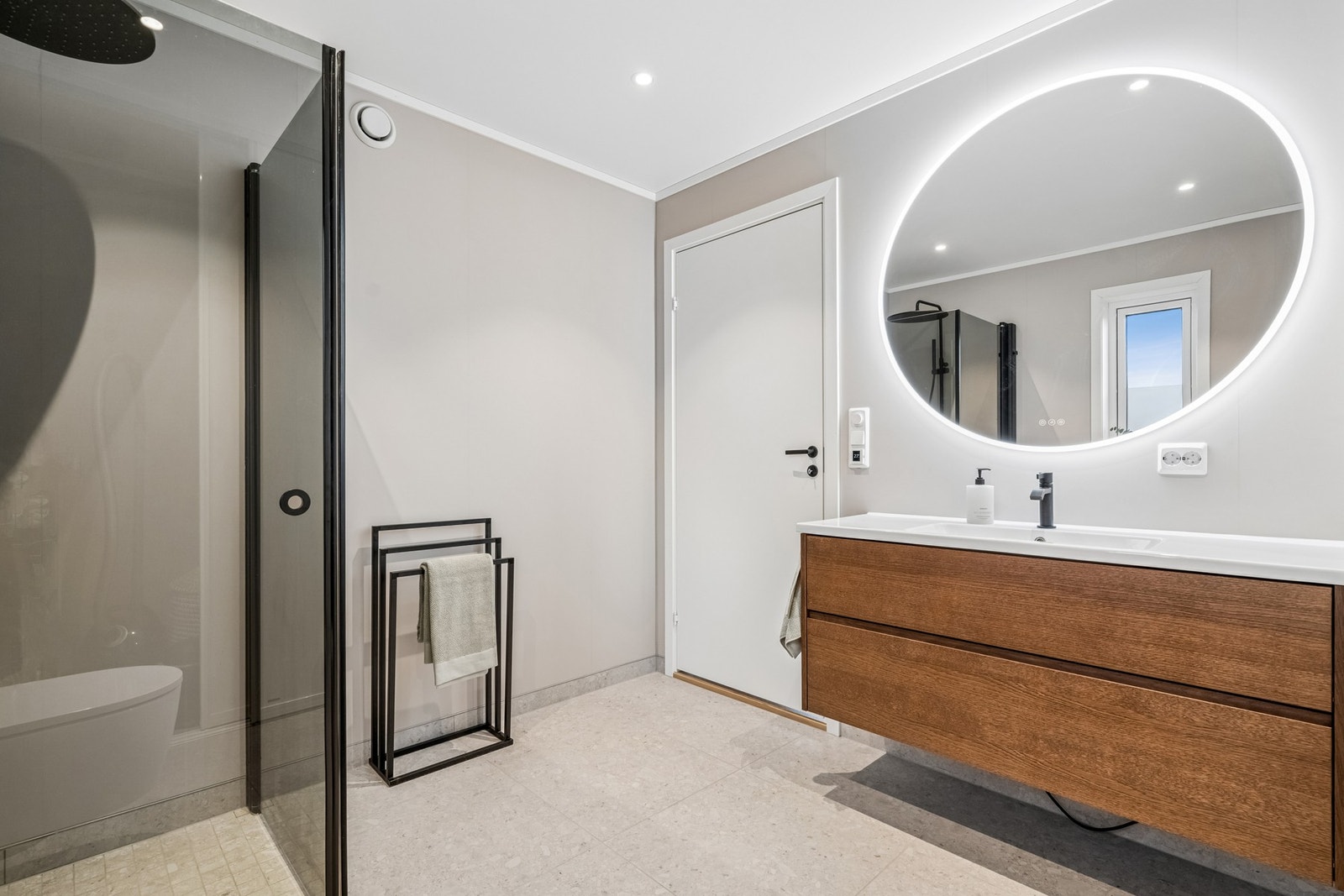 Badet et utformet i nøytrale farger med fliser og varmekabler i gulvet. Galleribilde