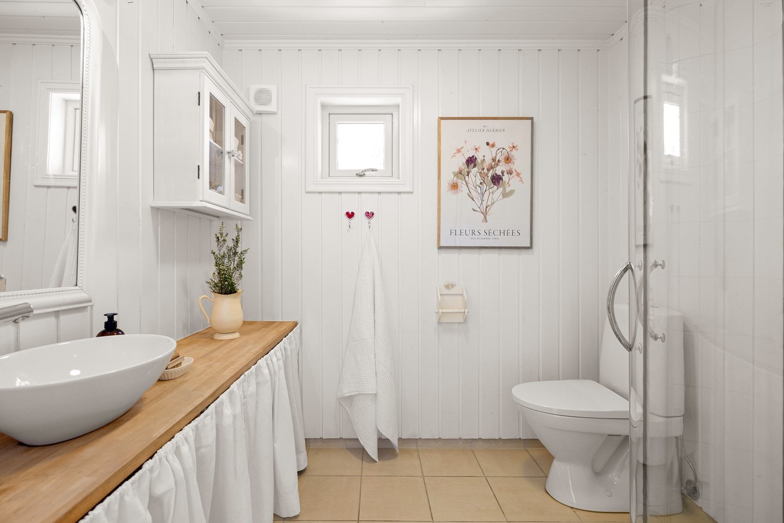 Moderne bad med flislagt gulv og malt veggpanel. Dusjsone med glassdører. Galleribilde