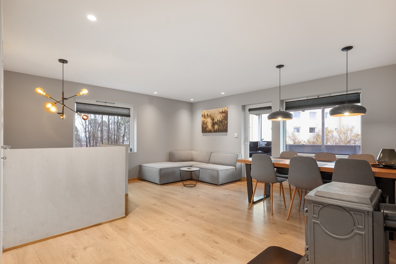 Stuen har lyse overflater på veggene, laminatgulv og en peisovn som sørger for varme på kalde dager. Galleribilde