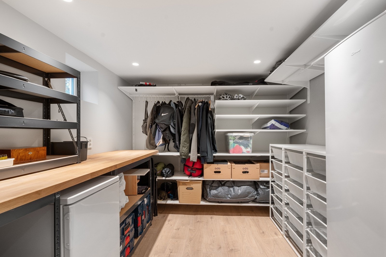 Kjelleren byr også på rikelig med oppbevaringsplass i to boder. En av bodene er innredet med praktiske hyller og klestang for klær. Galleribilde