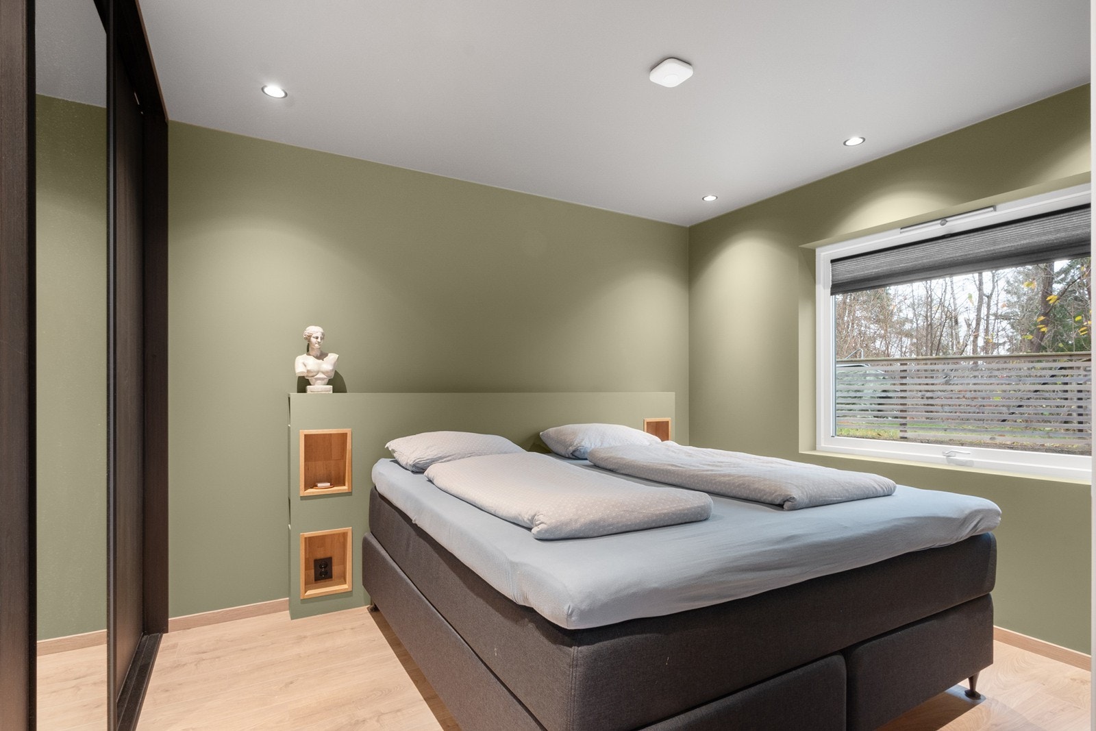 Det romslige hovedsoverommet er malt i en lun grønntone og gir plass til både dobbeltseng og en praktisk garderobe. Galleribilde