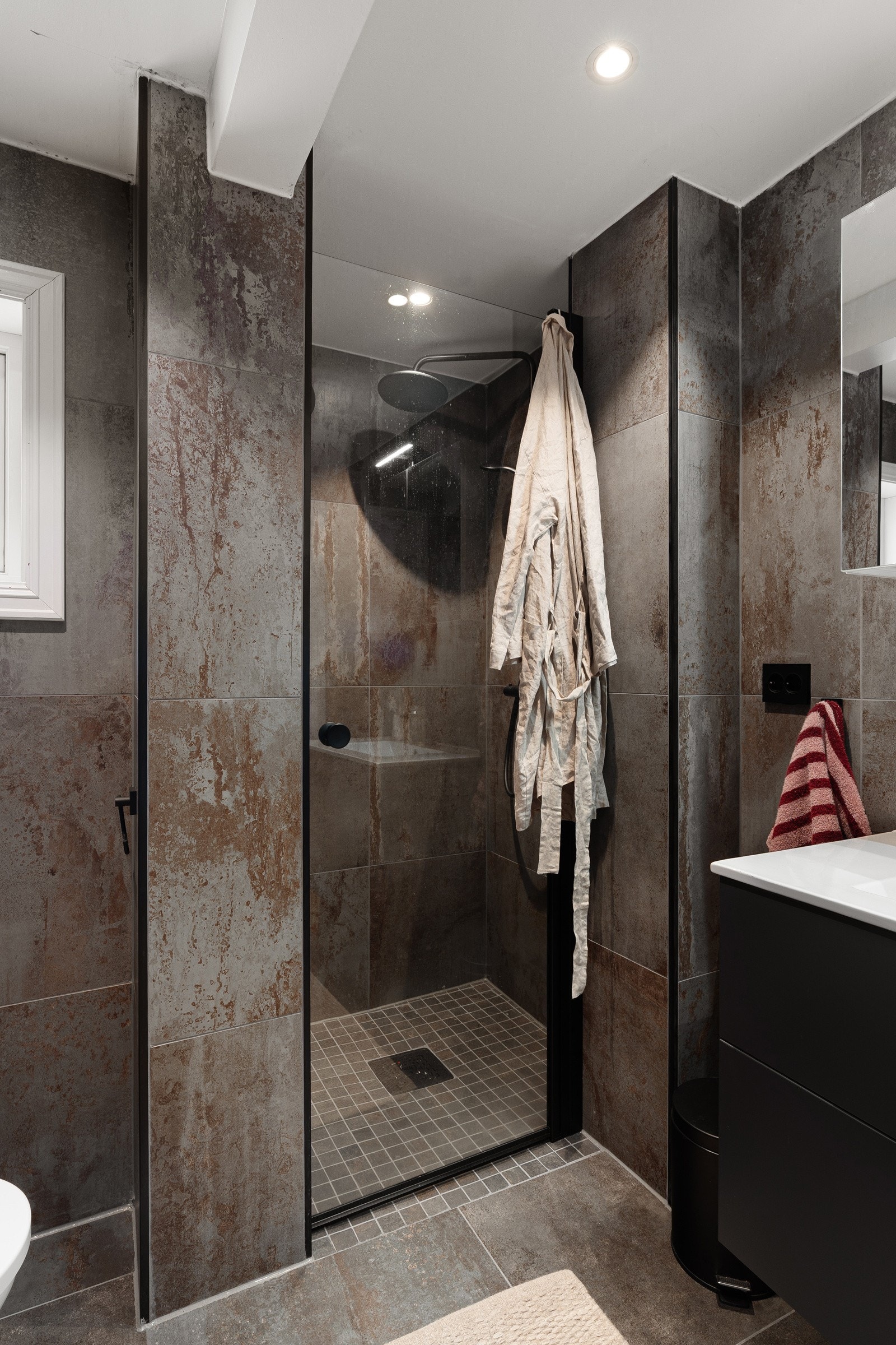 Badet er renovert i 2025, og framstår moderne. Utstyrt med stort dusjhjørne, vegghengt wc og plass for vaskemaskin. Galleribilde