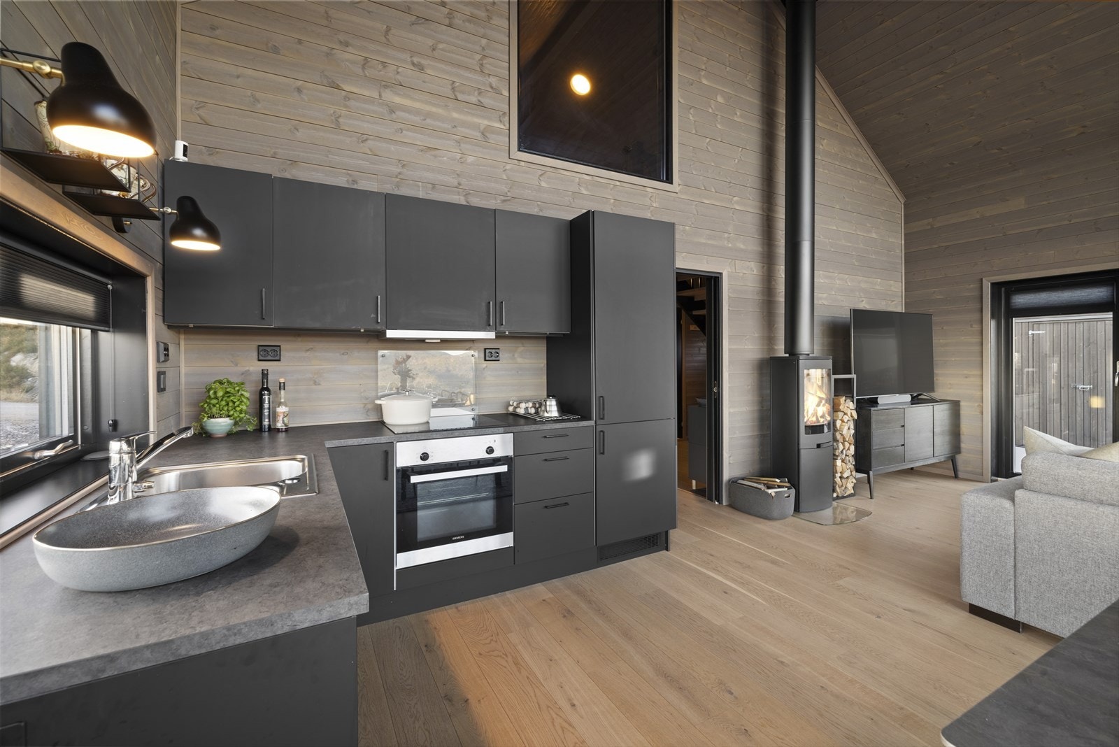 Kjøkkenet har sorte slette fronter og laminert benkeplate Galleribilde