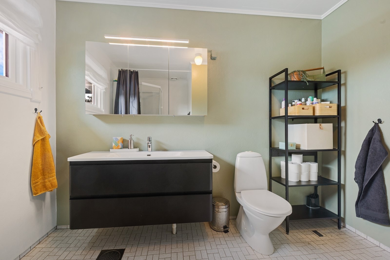 Innredningen består av servant med skuffer, speilskap, gulvmontert toalett og dusjkabinett. Galleribilde