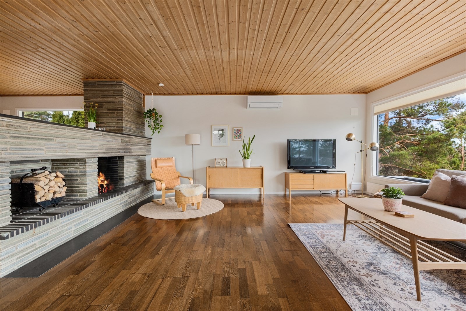 Hovedstuen har både en stemningsfull peisovn og en effektiv varmepumpe som sikrer et behagelig inneklima året rundt. Galleribilde