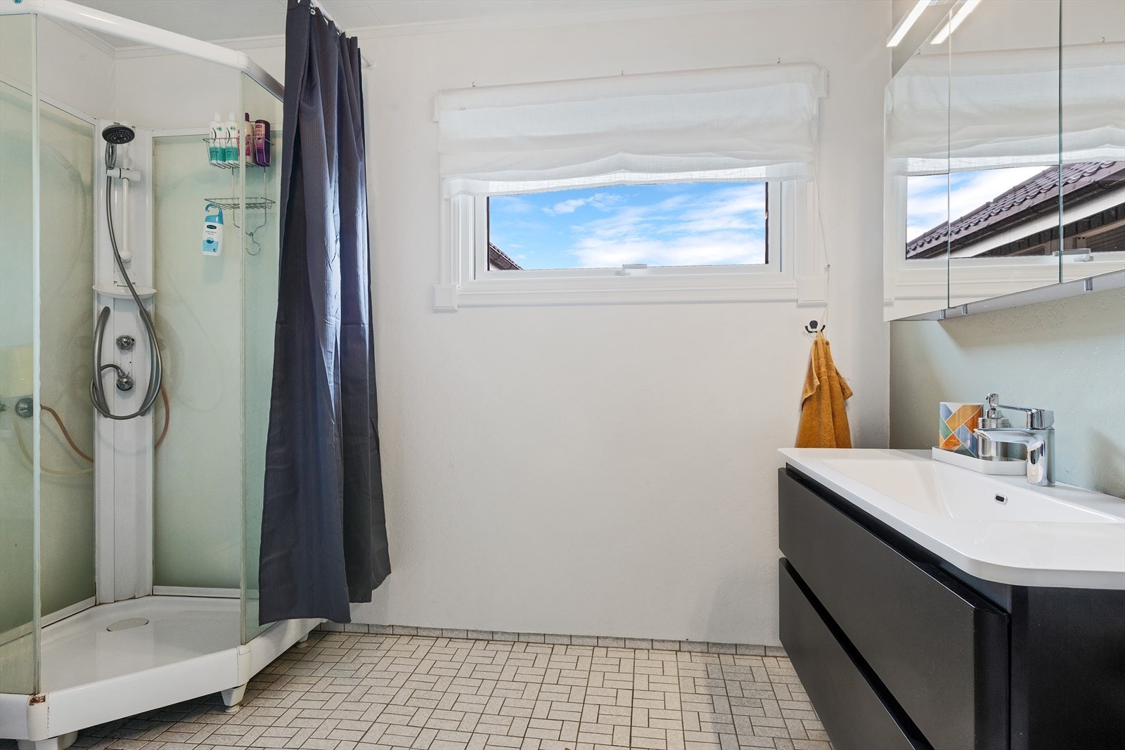 Badet i første etasje er fra byggeåret 1973. Det har tapetserte vegger med sokkelflis og tak-ess i himlingen. Gulvet er belagt med fliser og har gulvvarme. Galleribilde