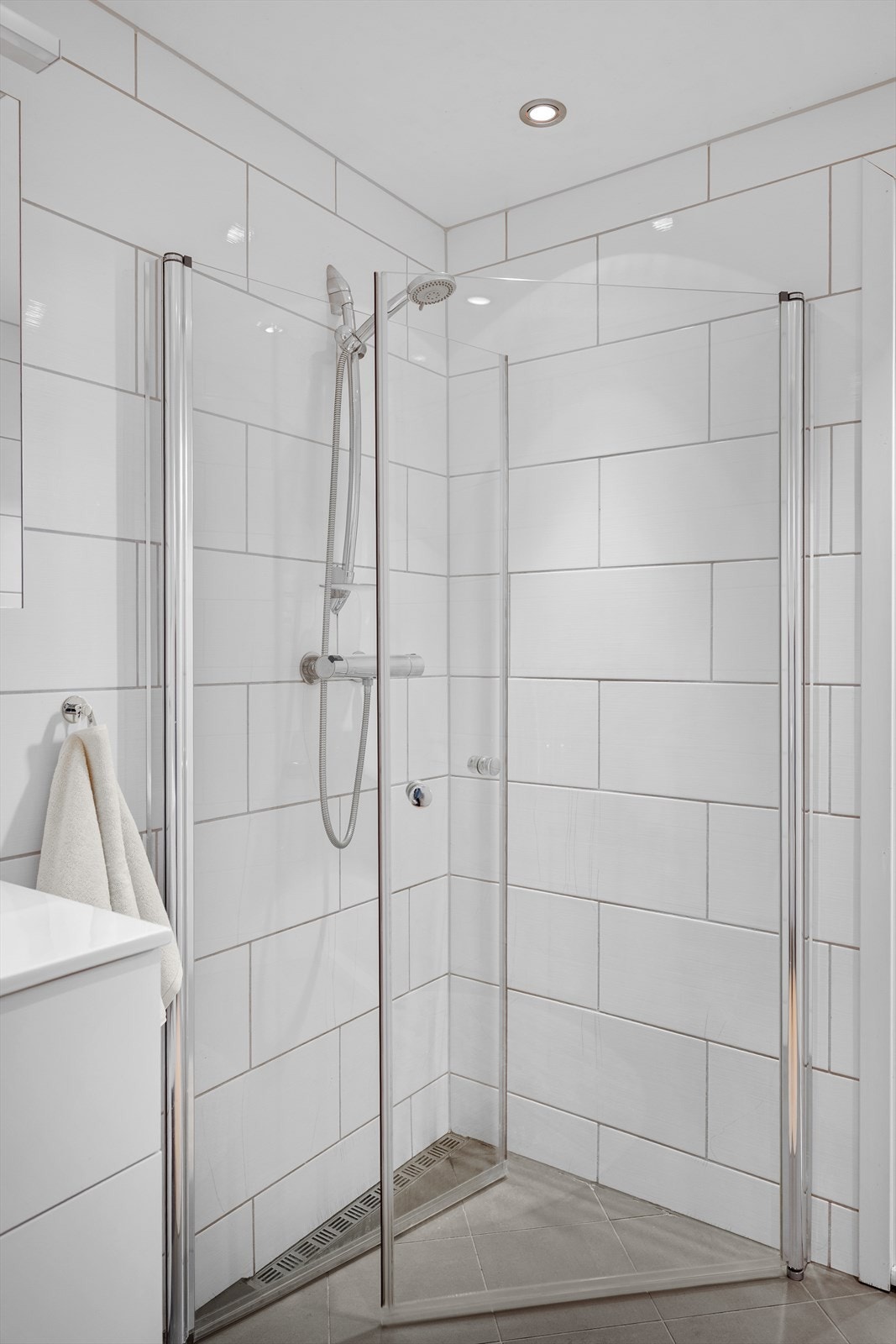 Flislagt bad med dusjhjørne i glass og moderne armaturer. Galleribilde