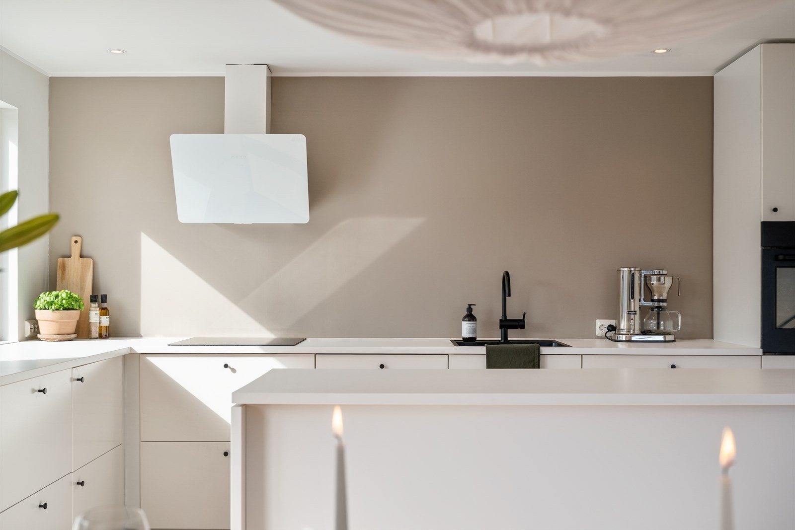 Sosial kjøkkenløsning med kjøkkenøy og åpen utforming mot spiseplass. Galleribilde