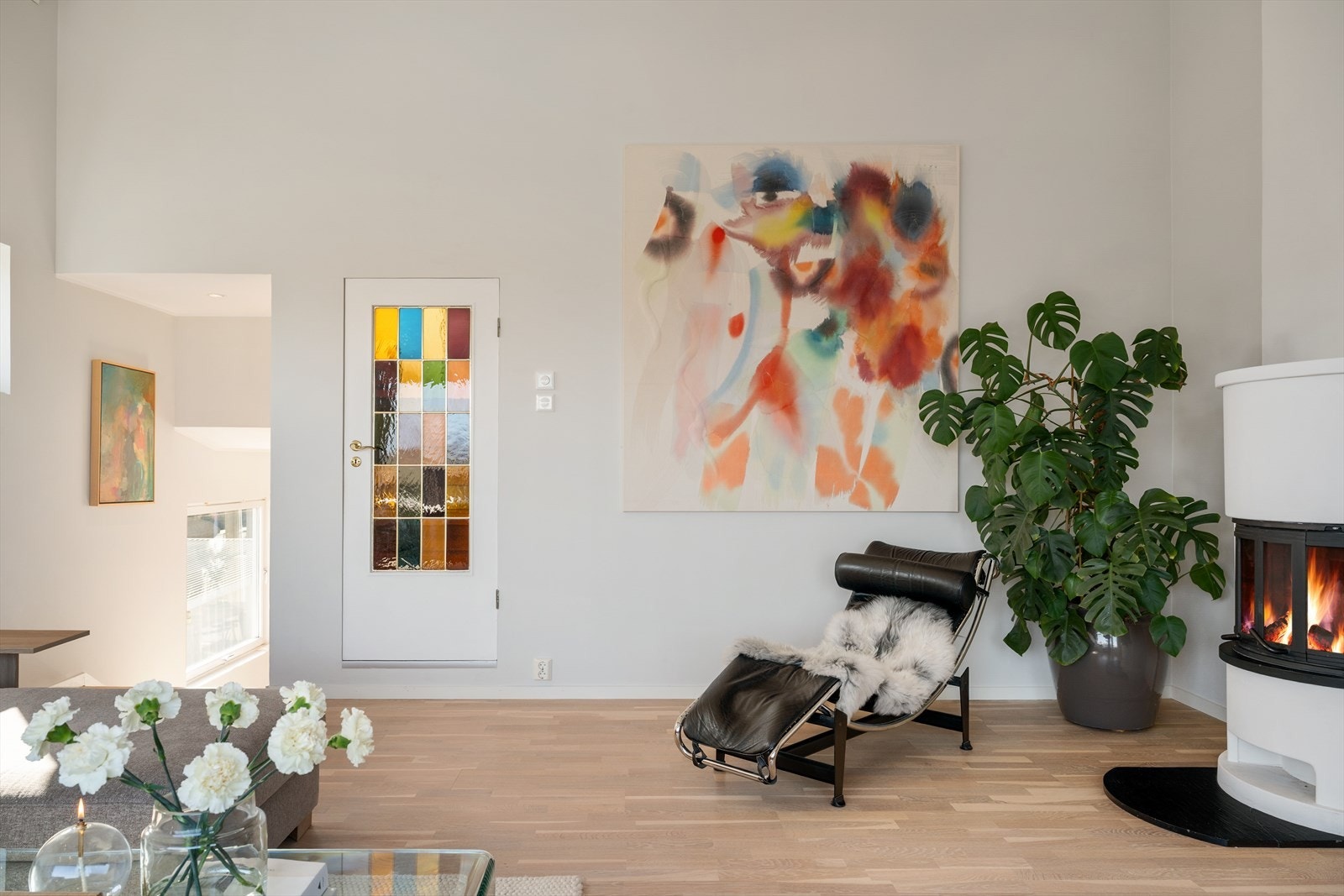 Stue med gjennomført og stilrent uttrykk, kombinert med peis som skaper en lun og behagelig atmosfære. Galleribilde