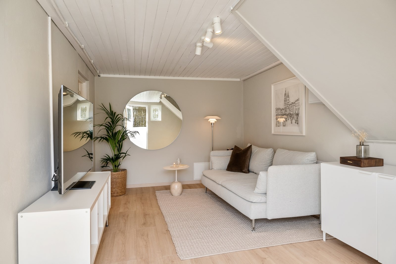 Innbydende kjellerstue med lune fargetoner og plass til sofa og TV-sone. Galleribilde