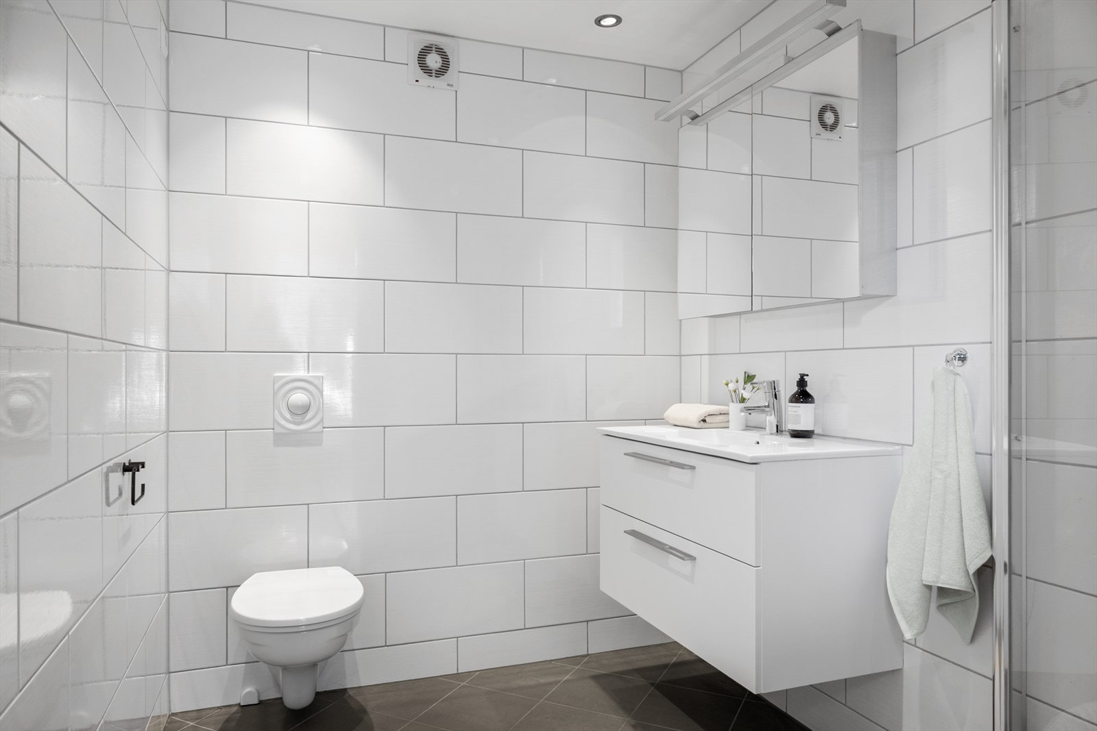 Delikat bad med tidløse materialvalg, vegghengt toalett og romslig planløsning. Galleribilde