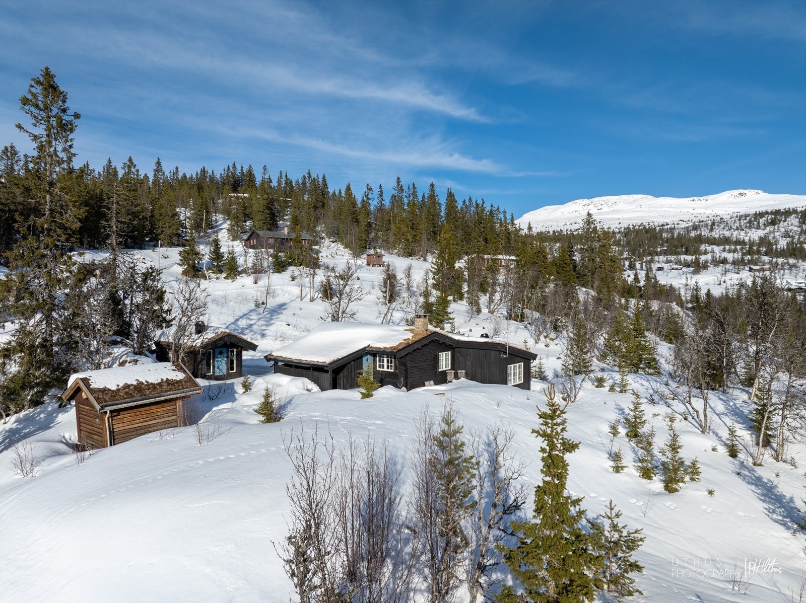 Klassisk fjellhytte med moderne, arkitekttegnet tilbygg beliggende på et høydedrag Galleribilde