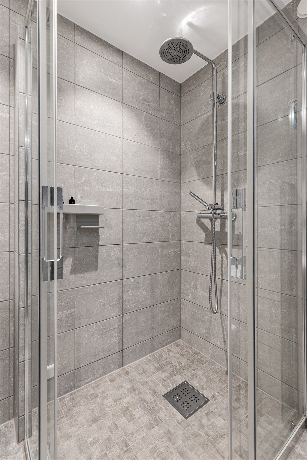 Dusjnisje med glassdører og regnfallsdusj. Galleribilde