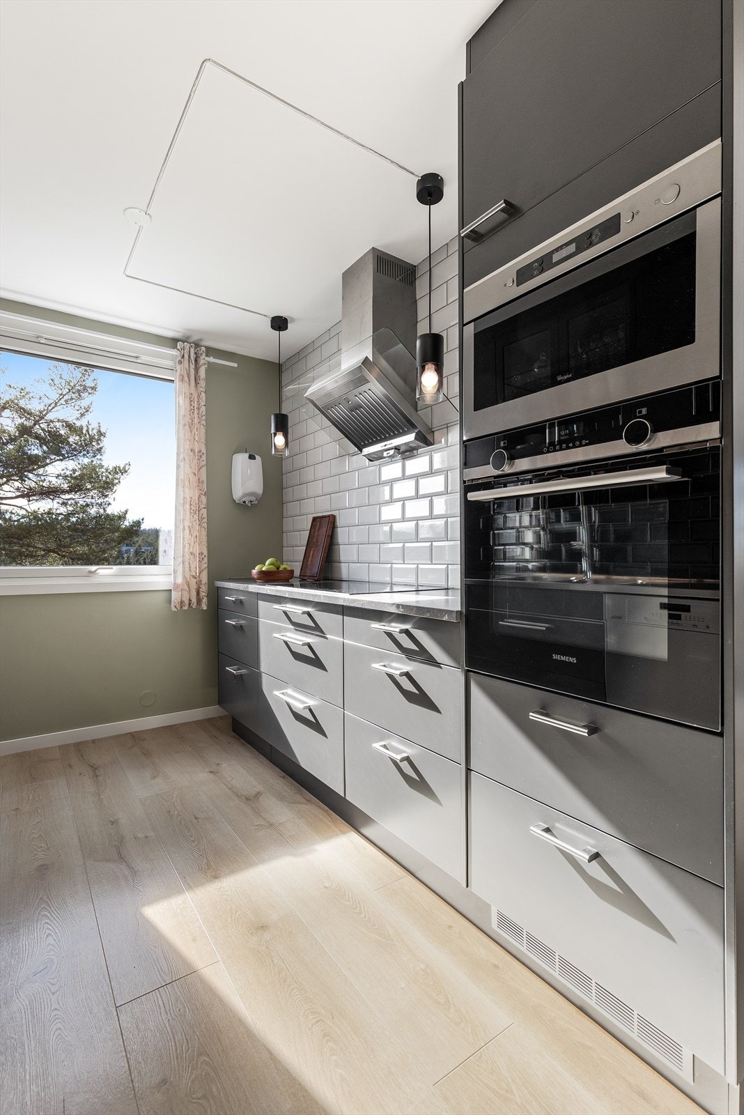 Høyskap med integrerte hvitevarer gir et ryddig uttrykk og optimal utnyttelse av plassen, samt stekeovn i optimal høyde. Galleribilde