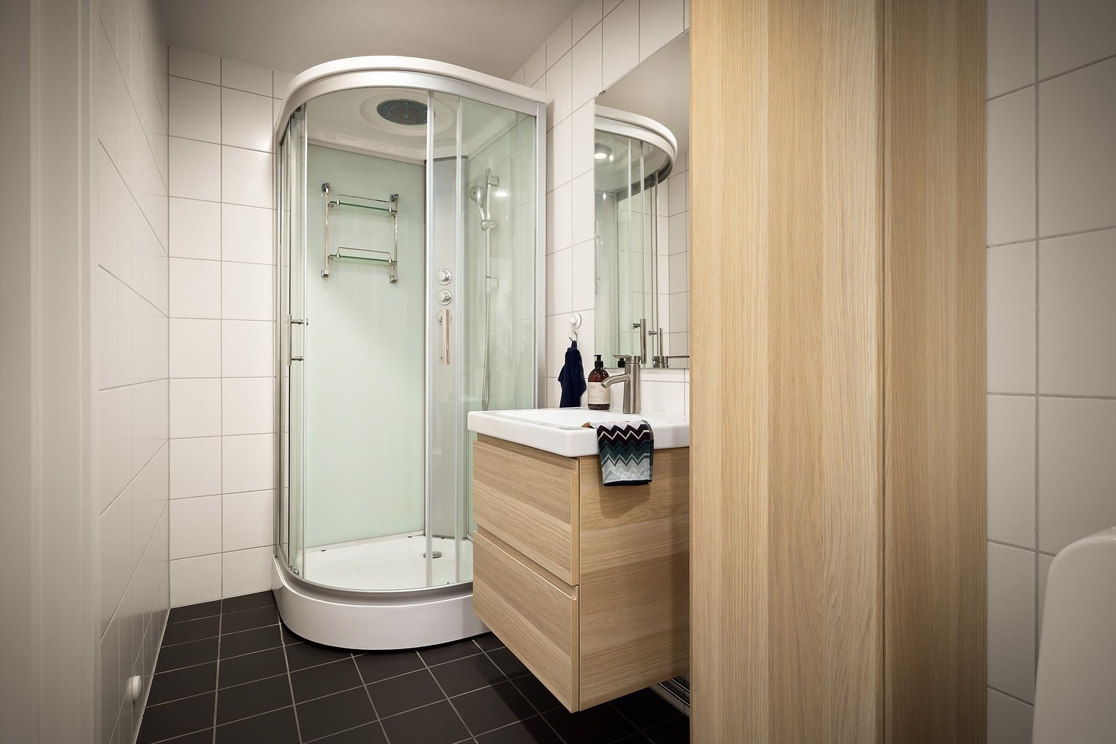 Badet er innredet med dusjkabinett, toalett og servantinnredning Galleribilde