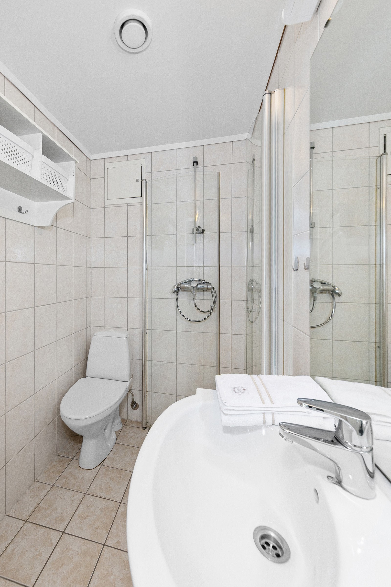 Dusjhjørne, toalett, servant med underskap og speil samt opplegg for vaskemaskin Galleribilde