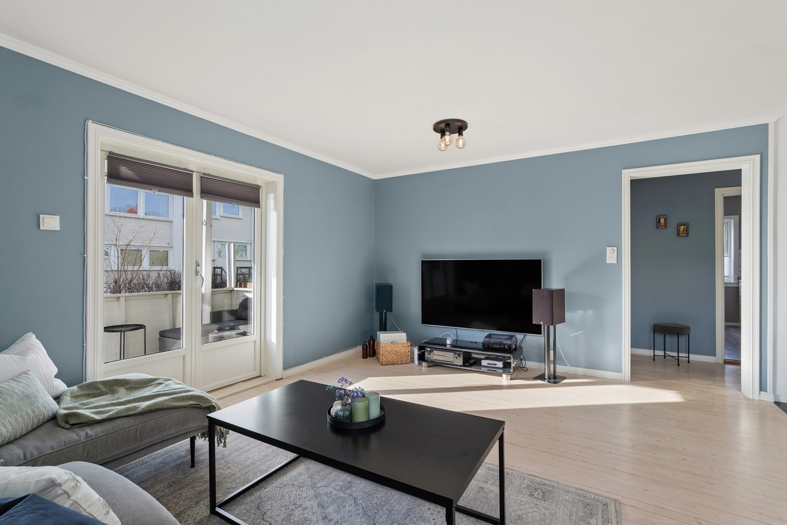 Stuen har originale furubord på gulvet og enkel tilgang til uteplassen. Galleribilde