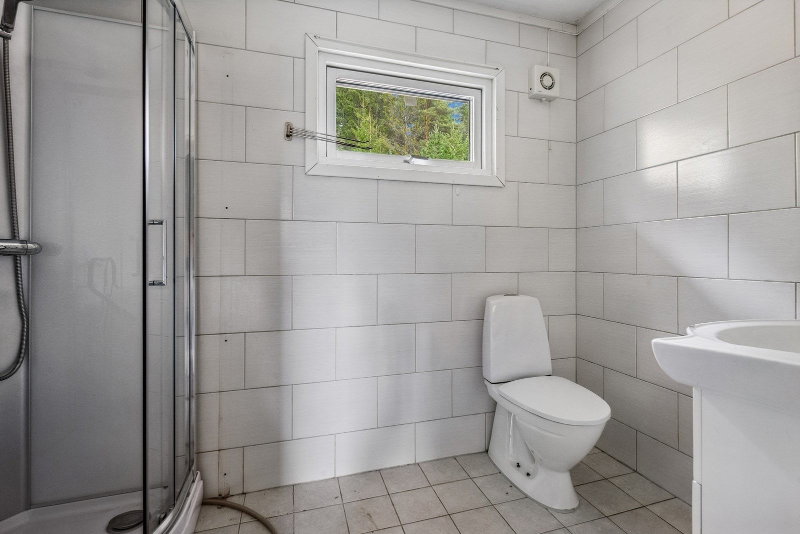 Flislagt bad med varme i gulv. Det er nyere vindu på badet. Galleribilde