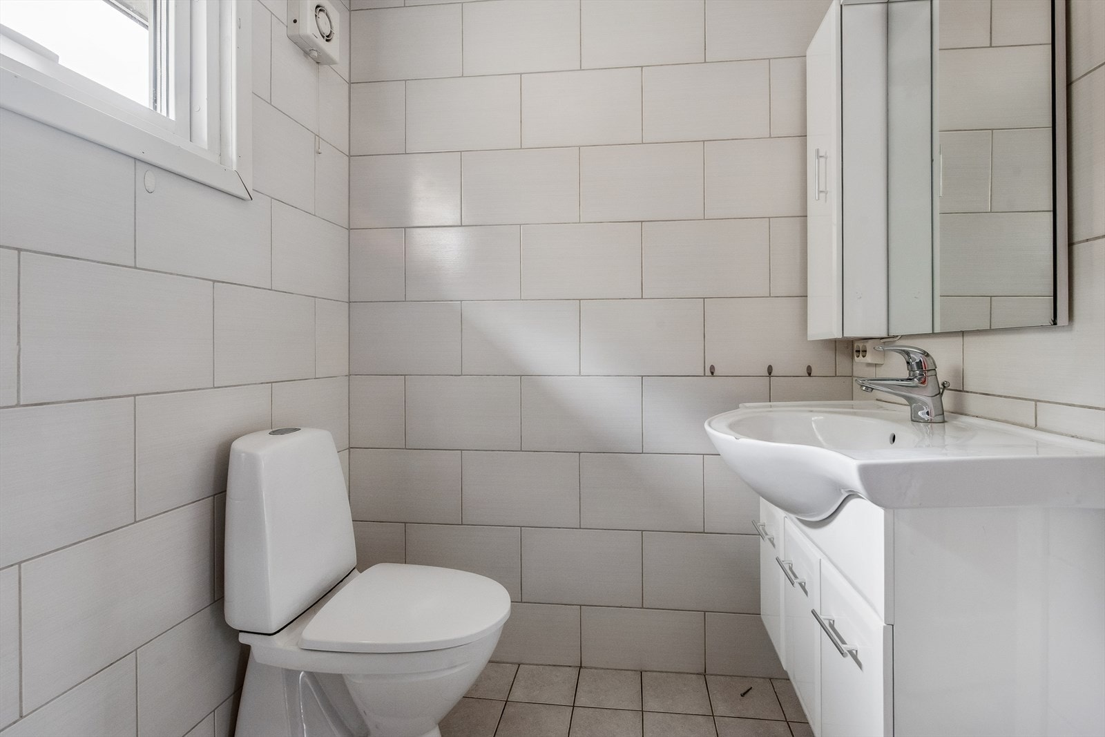 Badet inneholder baderomsinnredning, toalett og dusjkabinett. Galleribilde