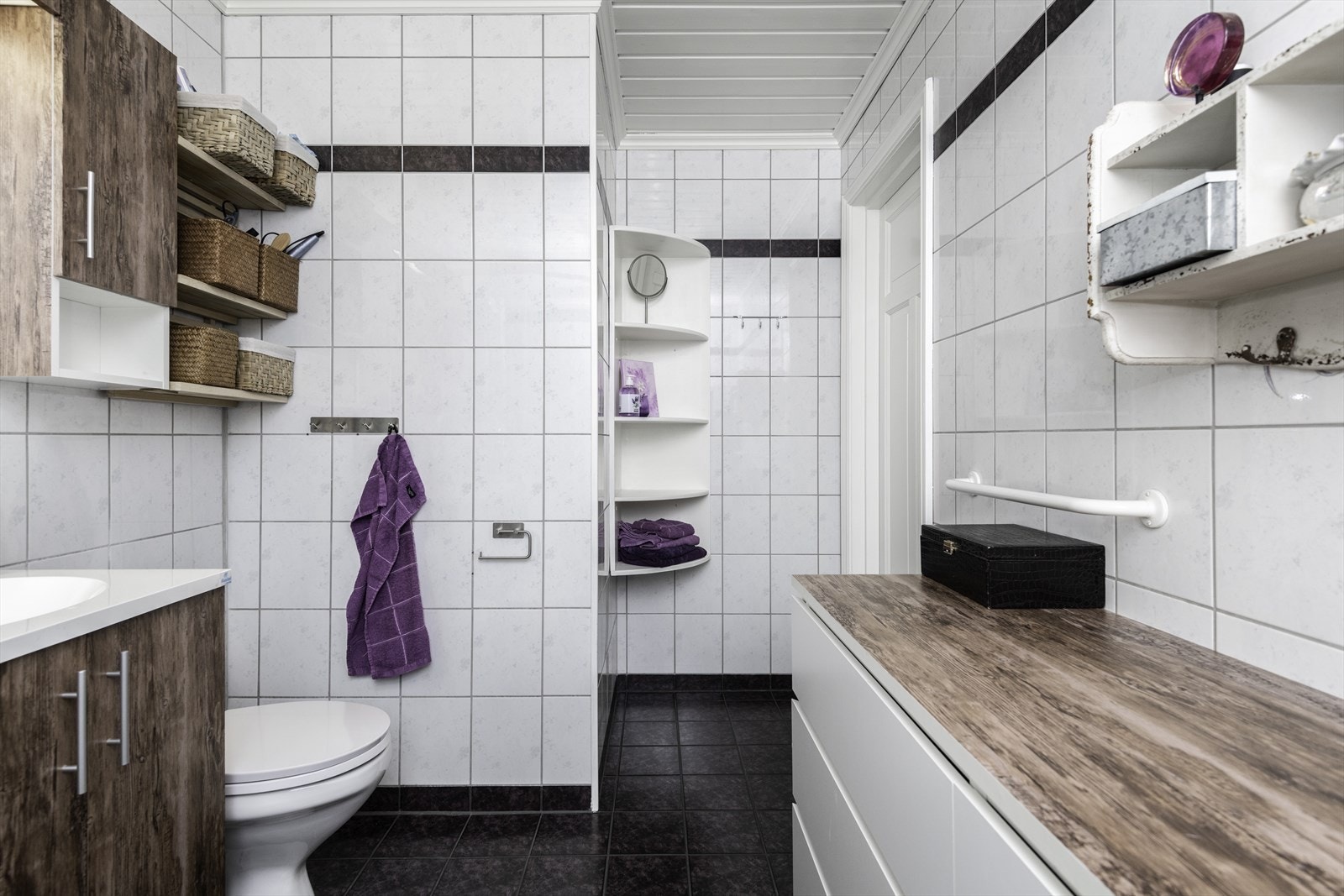 Badet er flislagt på gulv og vegger og har panel i taket. Galleribilde