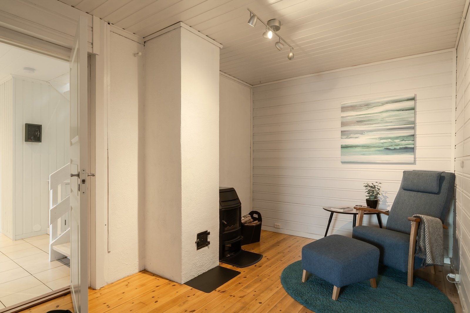 Sokkelens stue har en lite vedovn og plass til liten sittegruppe ved. Galleribilde
