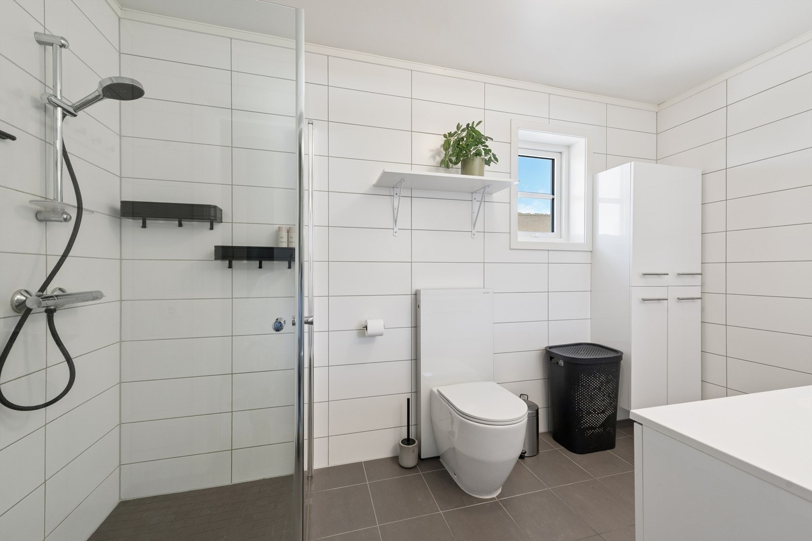 Innredningen består av servant med underskap, vegghengt toalett og et høyskap for ekstra oppbevaring. Galleribilde