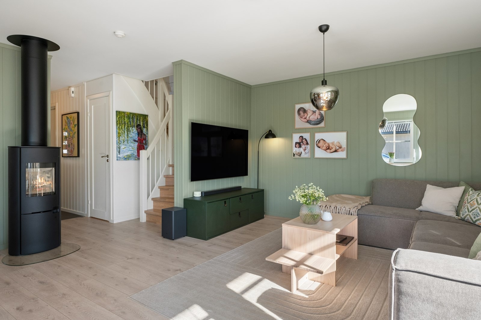 En moderne vedovn er sentralt plassert og gir både effektiv varme og en hyggelig atmosfære. Galleribilde