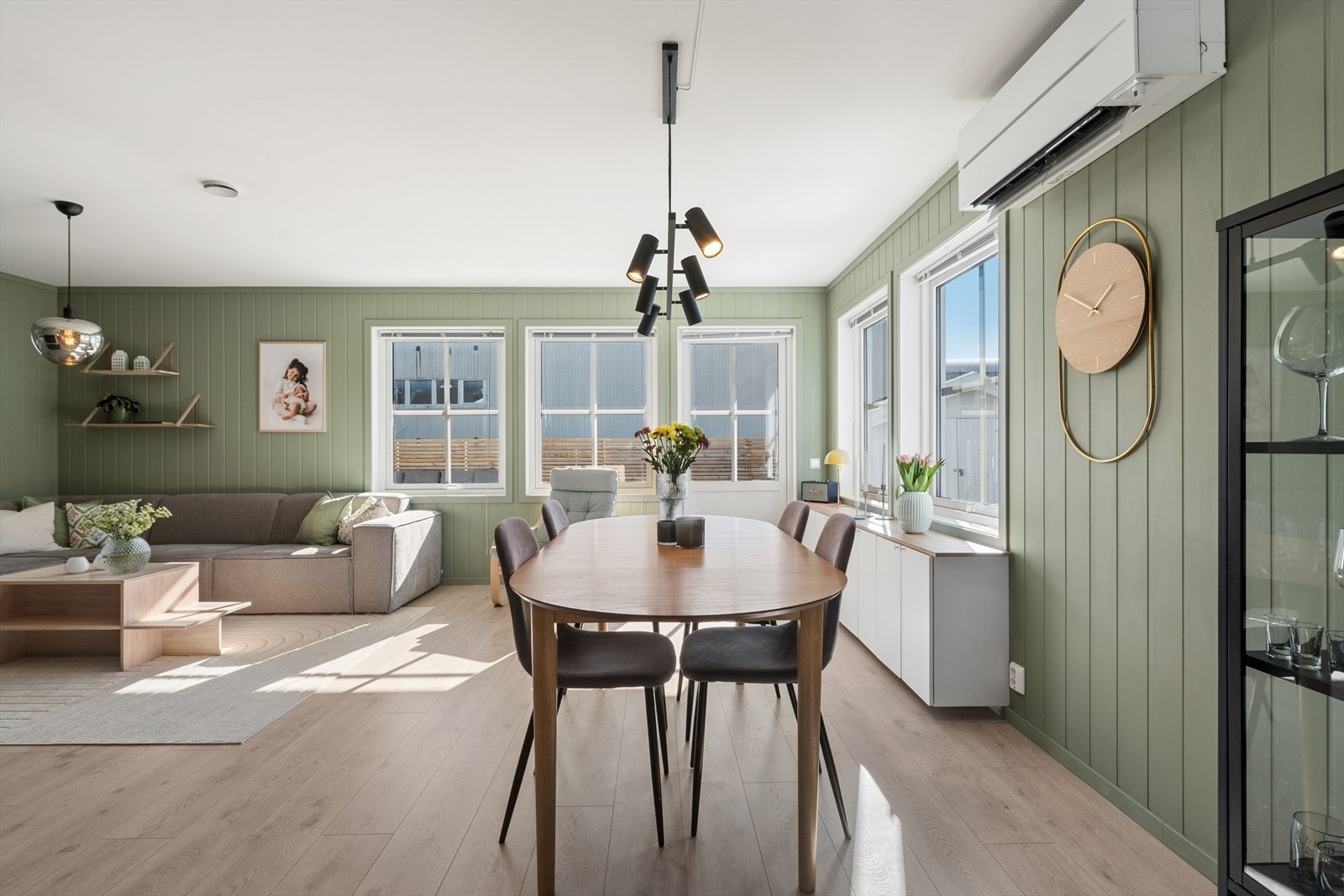 Store vindusflater gir rikelig med dagslys, og det er god plass til både sofagruppe og spisebord. Galleribilde