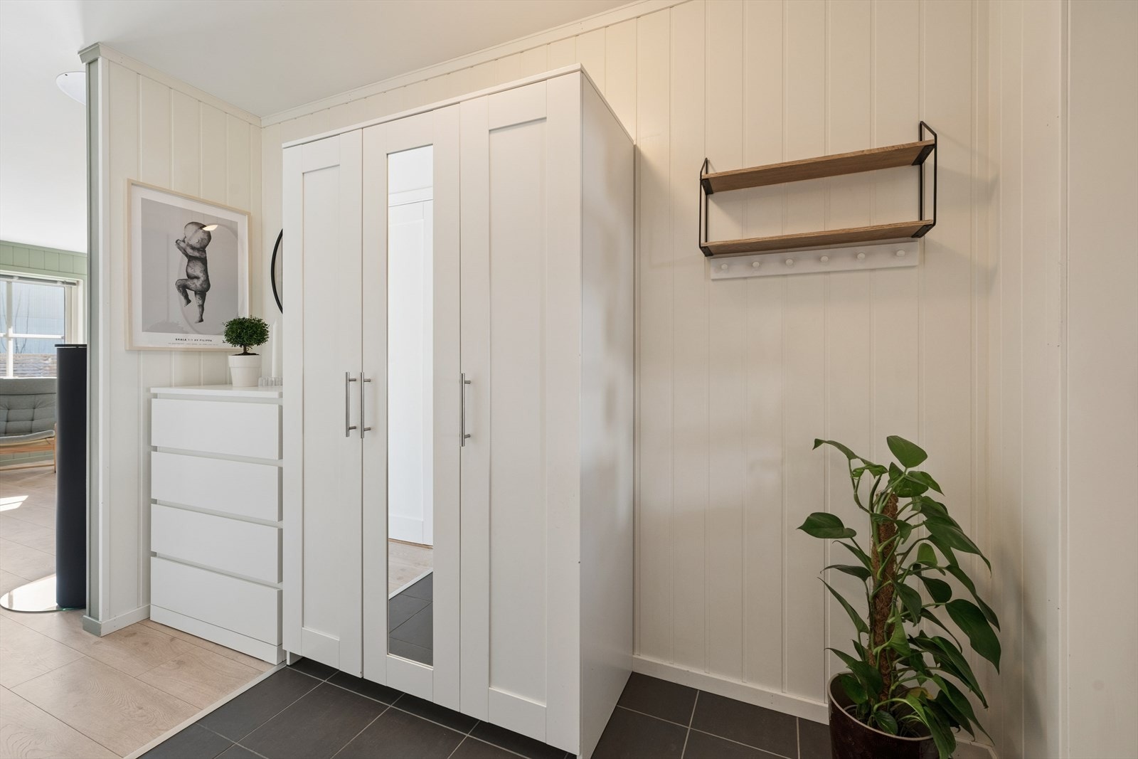 Entréen har flislagt gulv i inngangspartiet og god plass til oppbevaring av yttertøy og sko. Galleribilde