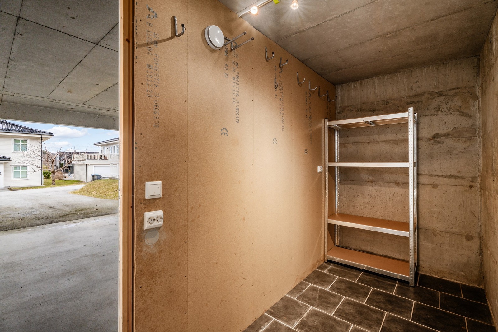 Praktisk sportsbod i bakkant av carport, med belysning. Galleribilde
