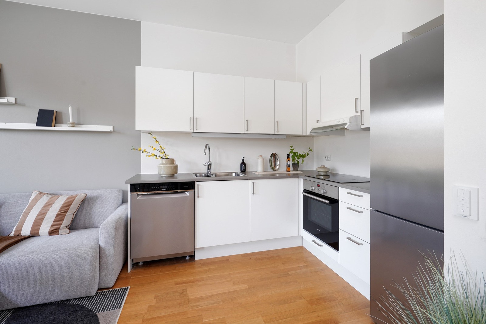 Pent, tidløst kjøkken med integrert platetopp og stekeovn. Galleribilde