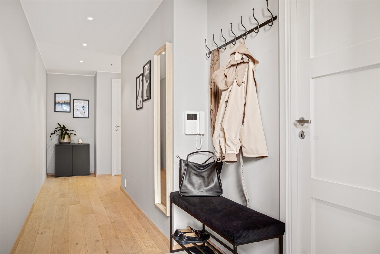 Man kommer inn i en lys entré med downlights i himling og en flott enstavs parkett på gulvet. Galleribilde