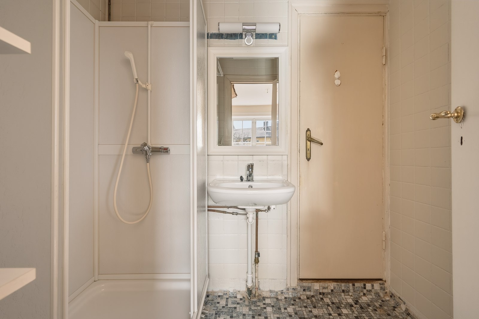 Badet er i hovedsak fra byggeår og er innredet med dusjkabinett og servant. Galleribilde