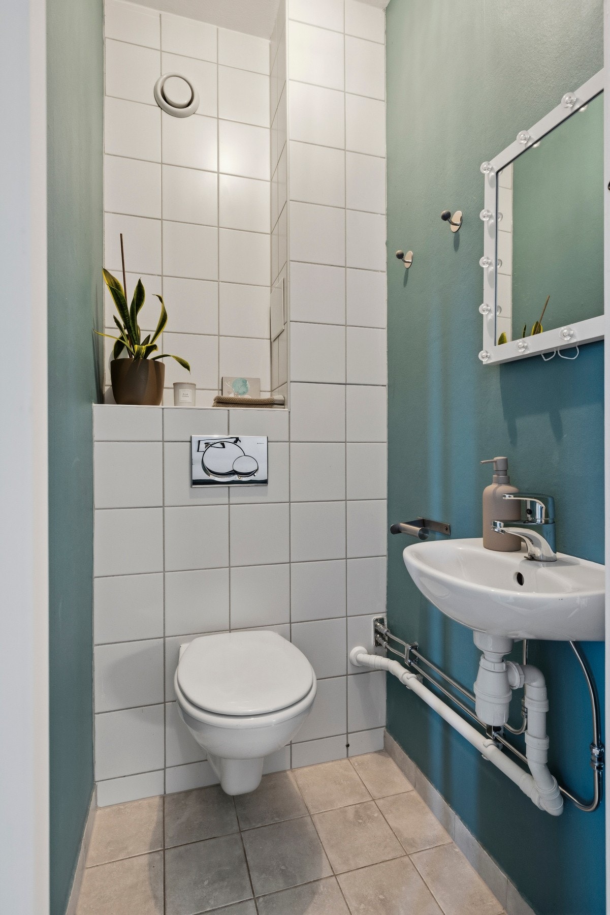 Toalettrommet er utstyrt med servant i porselen og vegghengt toalett med innebygget sisterne Galleribilde