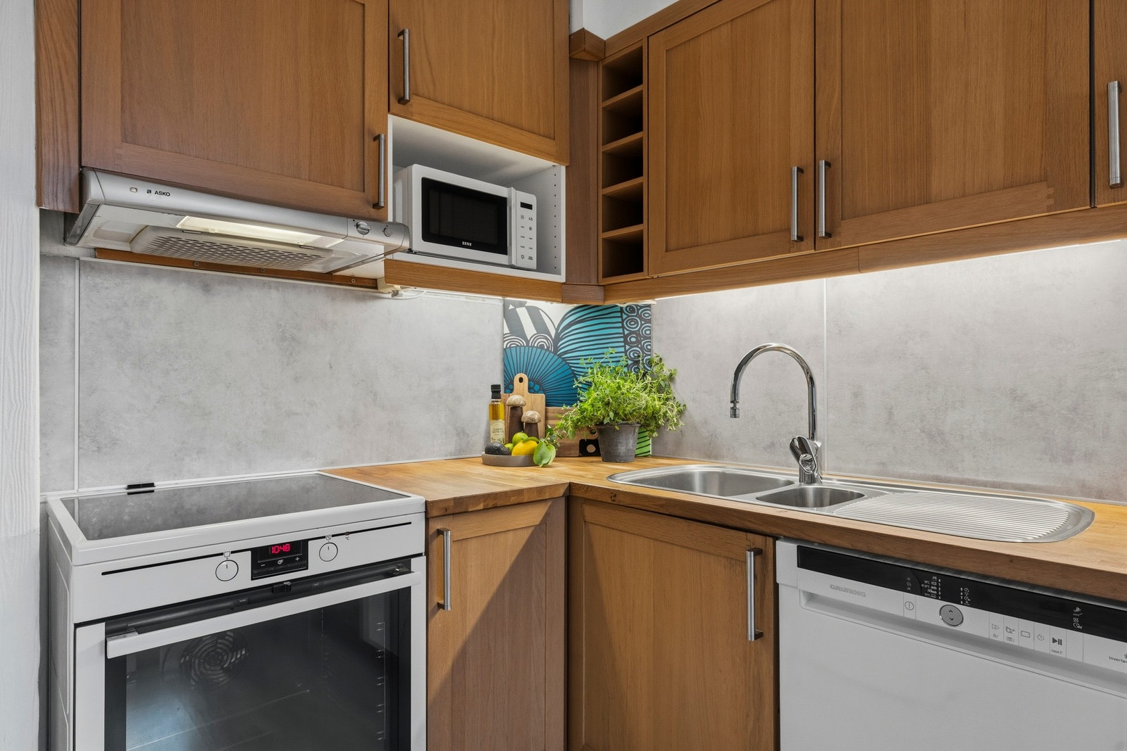 Frittstående hvitevarer inkluderer komfyr, oppvaskmaskin og kombiskap med kjøl og frys Galleribilde