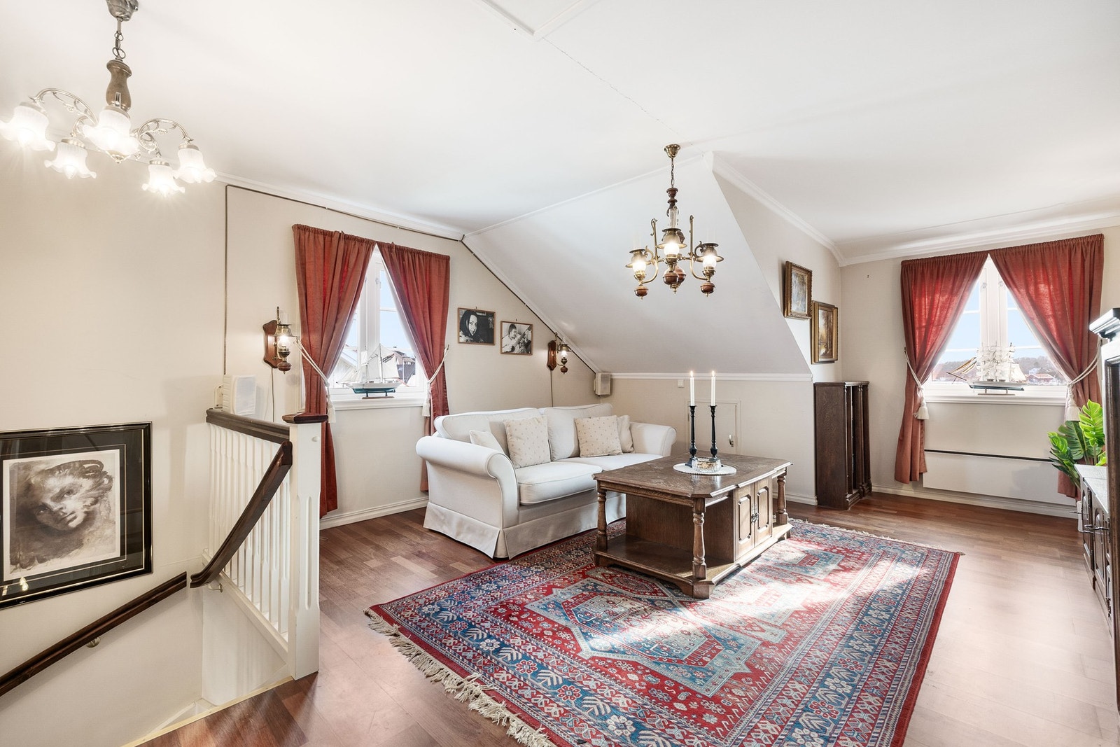 Lys og romslig loftsstue med noe skråtak og store vinduer. Galleribilde