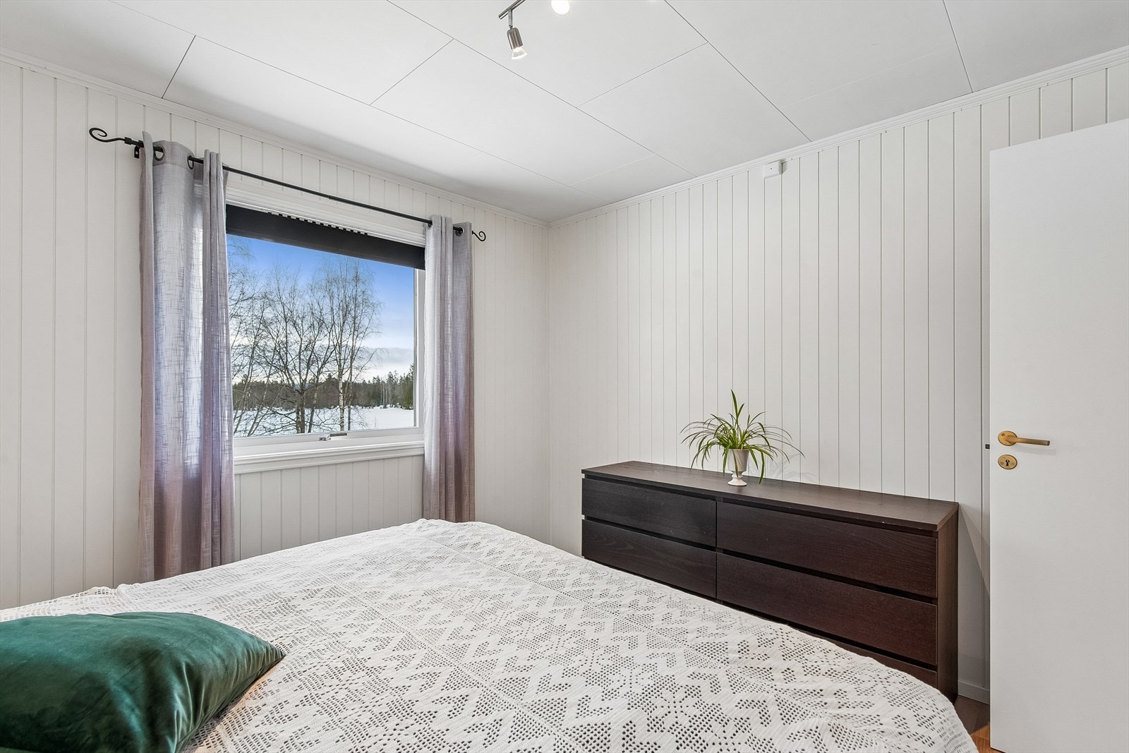 Rommet har malte panelplater på veggene og laminat på gulvet. Galleribilde
