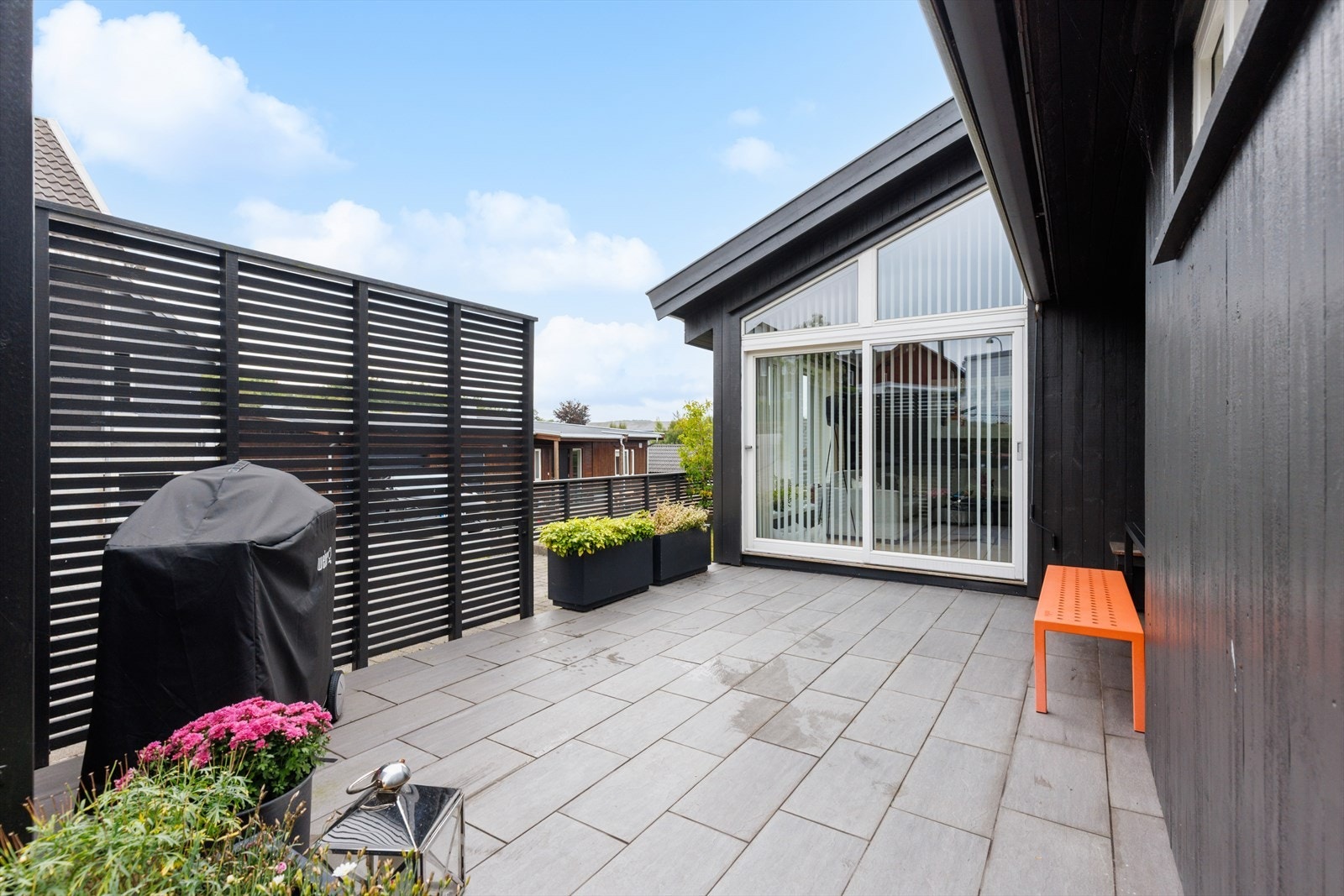 Flislagt uteplass med god plass til grill og utemøbler. Galleribilde