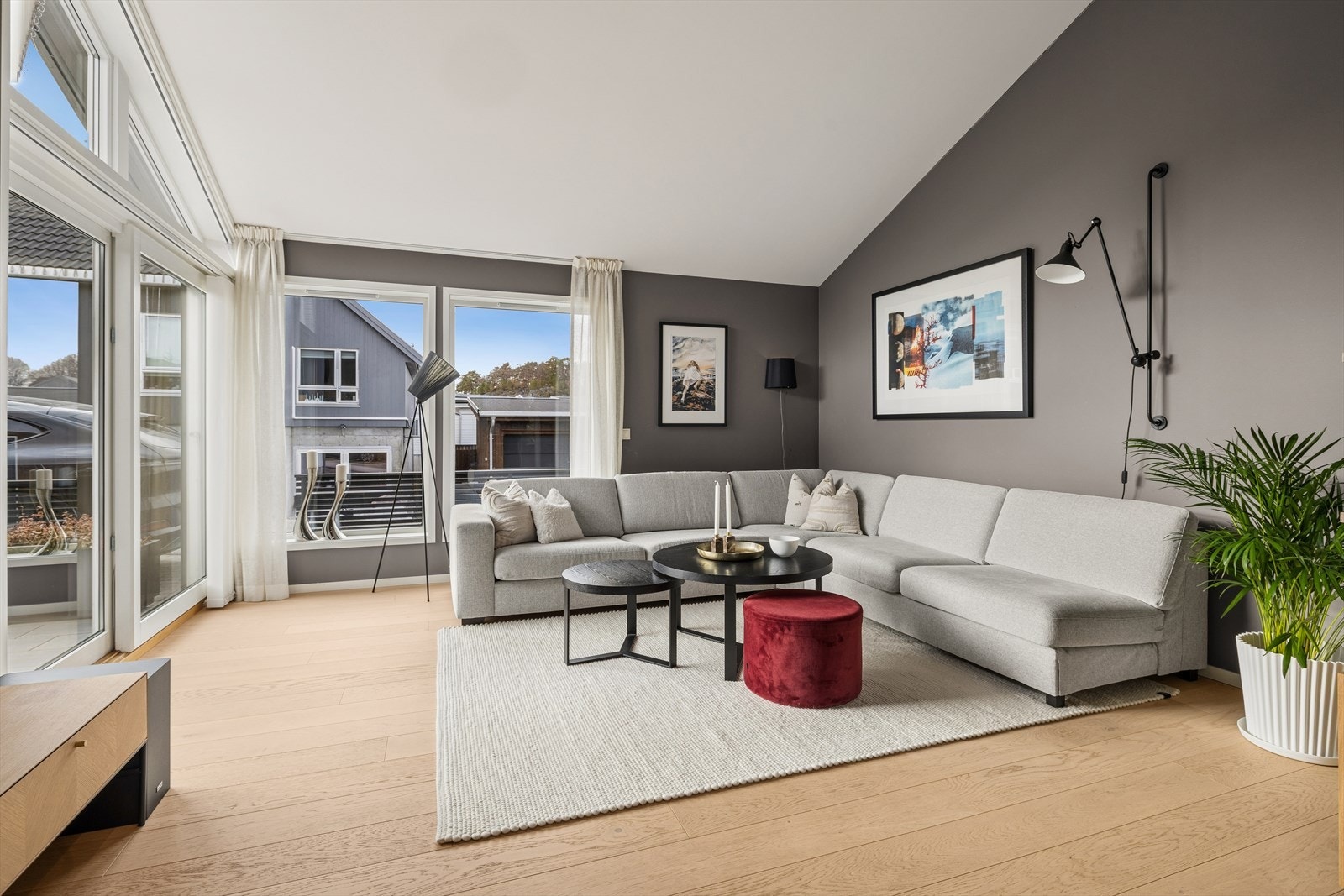 Store vindusflater gir godt lysinnslipp og utsikt fra stuen, med plass til stor sofagruppe. Galleribilde